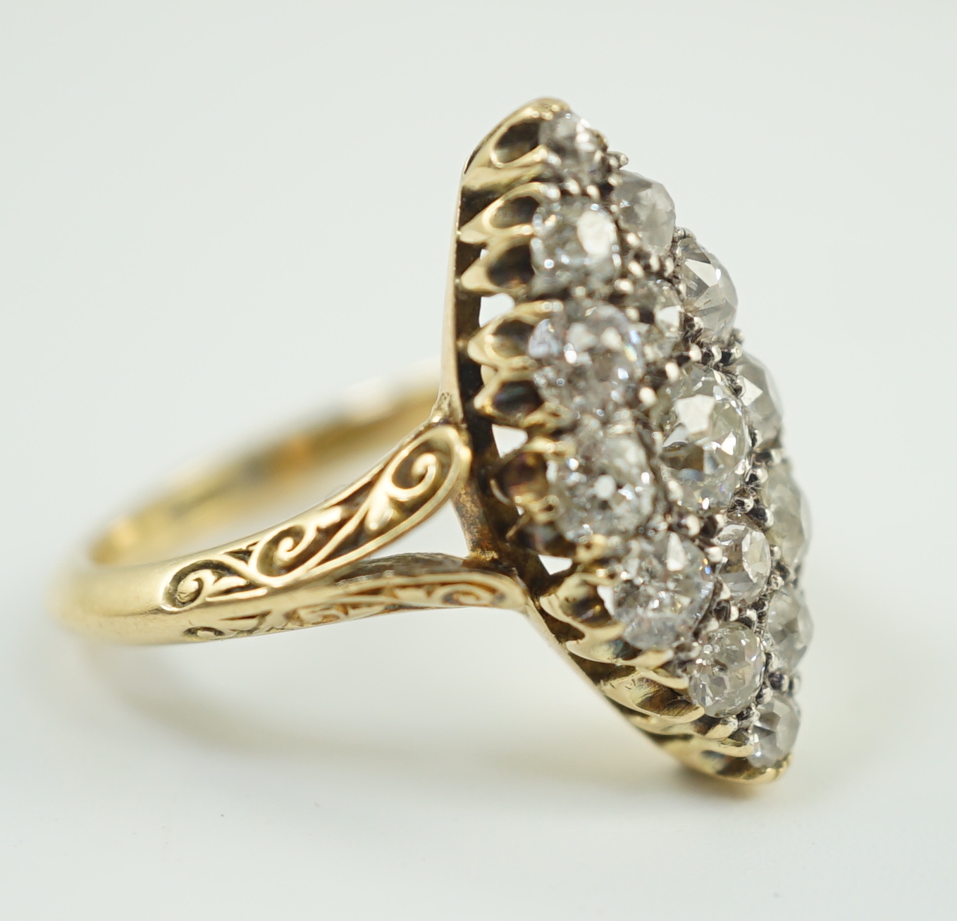 An early to mid 20th century 18ct gold and fifteen stone diamond cluster set marquise shaped ring